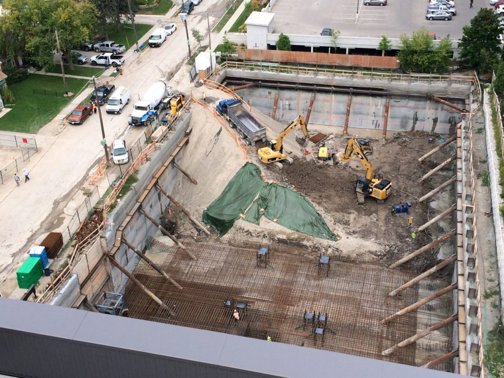 The Sage Condominium in Waterloo required an innovative shoring system that could facilitate a 10 meter foundation depth while working within encroachment restrictions. HCM implemented a soldier pile and shotcrete shoring system which utilized a single row of highly loaded rakers, designed by RWH Engineering Inc. (RWH).
